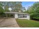White brick ranch house with carport, black railings, and landscaped yard at 6650 Queen Mill Se Rd, Mableton, GA 30126