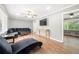 Spacious living room with hardwood floors, sectional sofa, and large TV at 6650 Queen Mill Se Rd, Mableton, GA 30126