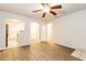 Open-concept living room with wood-look floors, ceiling fan, and views of the kitchen, hallway, and bathroom at 417 Tina Hely Ct, Stockbridge, GA 30281