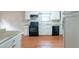 Efficient kitchen with white cabinets, black appliances, and light wood flooring at 4480 Joseph Dr, Snellville, GA 30039