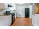 Efficient kitchen with white cabinets, black appliances, and light wood flooring at 4480 Joseph Dr, Snellville, GA 30039