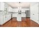 Modern kitchen featuring white cabinets, stainless steel appliances, and hardwood floors at 2166 Leatherstone Dr, Powder Springs, GA 30127