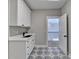 Laundry room with white cabinets, sink, and patterned floor at 3757 Wasson Way, Brookhaven, GA 30319