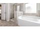Bathroom with shower, tub and tile flooring at 7843 Shertall St, Fairburn, GA 30213