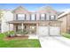 Brick two-story house with a two-car garage and landscaped lawn at 7843 Shertall St, Fairburn, GA 30213