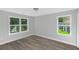 Bedroom with gray walls, wood-look flooring, and two windows at 43 Sims St, Locust Grove, GA 30248