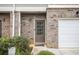 Townhome front door with a white garage door to the right at 8443 Douglass Trl, Jonesboro, GA 30236