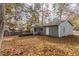 Gray house with deck and fenced backyard covered in autumn leaves at 6415 Grey Fox Way, Riverdale, GA 30296