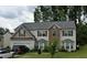 Two-story home with stone accents, attached garage, and landscaped front yard at 6415 Grey Fox Way, Riverdale, GA 30296