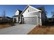 Gray siding two-story house with a two-car garage and landscaping at 231 Strawberry Ln, Woodstock, GA 30189