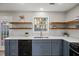 Updated kitchen featuring blue cabinetry, quartz countertops, and wooden floating shelves at 2080 Racquet Club Cir, Lawrenceville, GA 30043