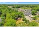 Aerial view of a house nestled in a wooded area with townhomes visible in the background at 1162 Joseph E Boone Nw Blvd, Atlanta, GA 30314