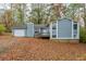 Gray house with attached garage and a yard full of autumn leaves at 9887 Live Oak Ct, Douglasville, GA 30135