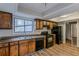 Kitchen with wood cabinets, black appliances, and vinyl flooring at 9887 Live Oak Ct, Douglasville, GA 30135