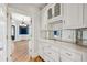 Butler's pantry with white cabinets, mirrored backsplash and granite countertop at 2195 Lake Shore Lndg, Alpharetta, GA 30005
