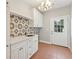 Laundry room with tile floors, white cabinets, and decorative tile backsplash at 2195 Lake Shore Lndg, Alpharetta, GA 30005