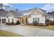 Tan house with gray roof, landscaping, and a paved driveway at 141 Legends Way, Hiram, GA 30141