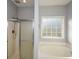 Clean bathroom with a shower/tub combo and a large window for natural light at 138 Slippery Rock Ct, Villa Rica, GA 30180