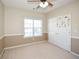 Simple bedroom with neutral walls and carpet, featuring a ceiling fan and window at 138 Slippery Rock Ct, Villa Rica, GA 30180