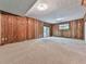 Finished basement with wood paneling and neutral carpeting at 3771 Club Nw Dr, Kennesaw, GA 30144