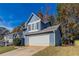 Blue two-story house with a white garage door and neat landscaping at 6016 King Way Walk, Lithonia, GA 30058