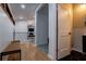 Light-filled hallway with wood floors, bench, and access to bathroom and upper level at 5088 Riverview Rd, Atlanta, GA 30327