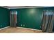 Large bedroom with dark green walls and neutral carpet at 3668 Deer Springs Pkwy, Ellenwood, GA 30294