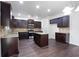 Spacious kitchen featuring dark wood cabinetry, granite countertops, and a center island at 5992 Mock Ives Ct, Sugar Hill, GA 30518