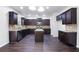 Well-appointed kitchen with dark cabinets, granite countertops, stainless steel appliances, and an island at 5992 Mock Ives Ct, Sugar Hill, GA 30518