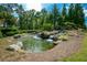 Community pond with a waterfall and landscaping at 650 Hemlock Trl, Canton, GA 30114