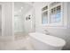 Bathroom with white tile, a freestanding tub, and a large walk-in shower at 1715 Sawnee Meadow Ln, Cumming, GA 30040