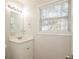 Clean bathroom with white vanity, mirror, and window with blinds at 894 Churchill Ct, Stone Mountain, GA 30083