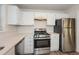 Kitchen with stainless steel appliances and white cabinets at 894 Churchill Ct, Stone Mountain, GA 30083
