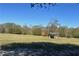Open pasture with a covered feeding area at 2431 Perkerson Mill Rd, Austell, GA 30106