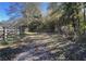 Dirt trail leads through wooded area with wooden fence at 2431 Perkerson Mill Rd, Austell, GA 30106