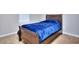 Small bedroom with a dark wood frame bed and blue bedding at 8432 Browns Mill Trce, Stonecrest, GA 30038