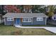 Newly renovated ranch home featuring a gray exterior, blue door, and landscaped yard at 26 Reeves St, Norcross, GA 30071