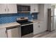 Modern kitchen with stainless steel appliances and blue tile backsplash at 26 Reeves St, Norcross, GA 30071