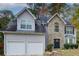Two-story house with stone accents, two-car garage, and landscaped yard at 3579 Oakshire Se Way, Atlanta, GA 30354