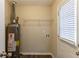 Laundry room with washer/dryer hookups, shelving, and water heater at 6677 Songwood Dr, Austell, GA 30168
