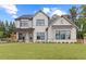 Two-story farmhouse with white brick, gray roof, and a welcoming front porch at 2810 Herrington Dr, Cumming, GA 30041