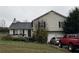 Tan two-story house with a two-car garage and cars parked in the driveway at 132 Scarlett Place Dr, Bowdon, GA 30185