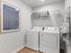 Convenient laundry room with washer, dryer, and overhead shelving at 4175 Viola Pl, Atlanta, GA 30349