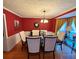 Formal dining room with hardwood floors, chandelier, and red walls at 4761 Habersham Way, Conyers, GA 30094