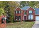 Two-story brick home with a red door and landscaping at 4761 Habersham Way, Conyers, GA 30094
