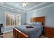 Bedroom with wood bed frame, blue bedding, and plantation shutters at 3423 Mulberry Lane Ct, Dacula, GA 30019