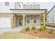 Covered front porch with brick columns and a blue front door at 3952 Adler Cir, Buford, GA 30519