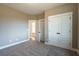 Bright bedroom featuring double doors and wall-to-wall carpet at 312 Brook Hollow Ln, Loganville, GA 30052