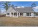 Gray house with covered patio, large backyard, and mature trees at 312 Brook Hollow Ln, Loganville, GA 30052