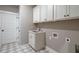 Laundry room with white cabinets and a utility sink at 312 Brook Hollow Ln, Loganville, GA 30052